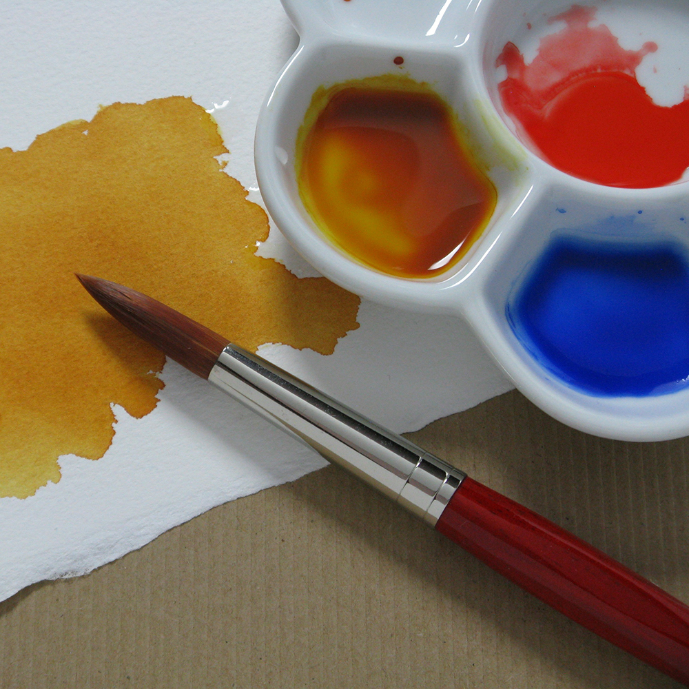 Watercolour paintbrush, palette and paper